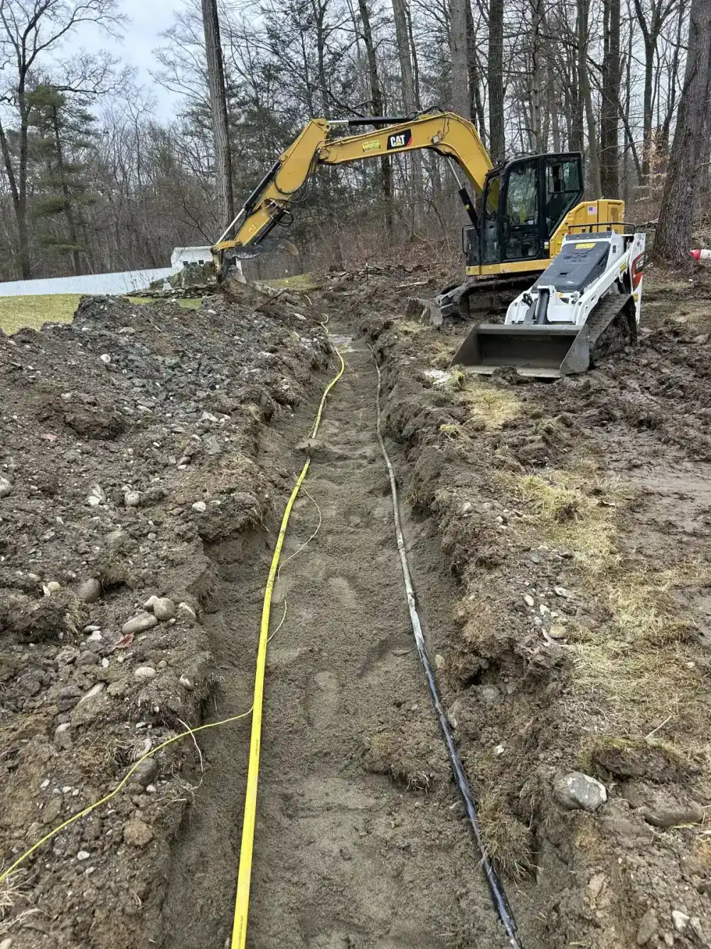 Excavator digging drainage trench