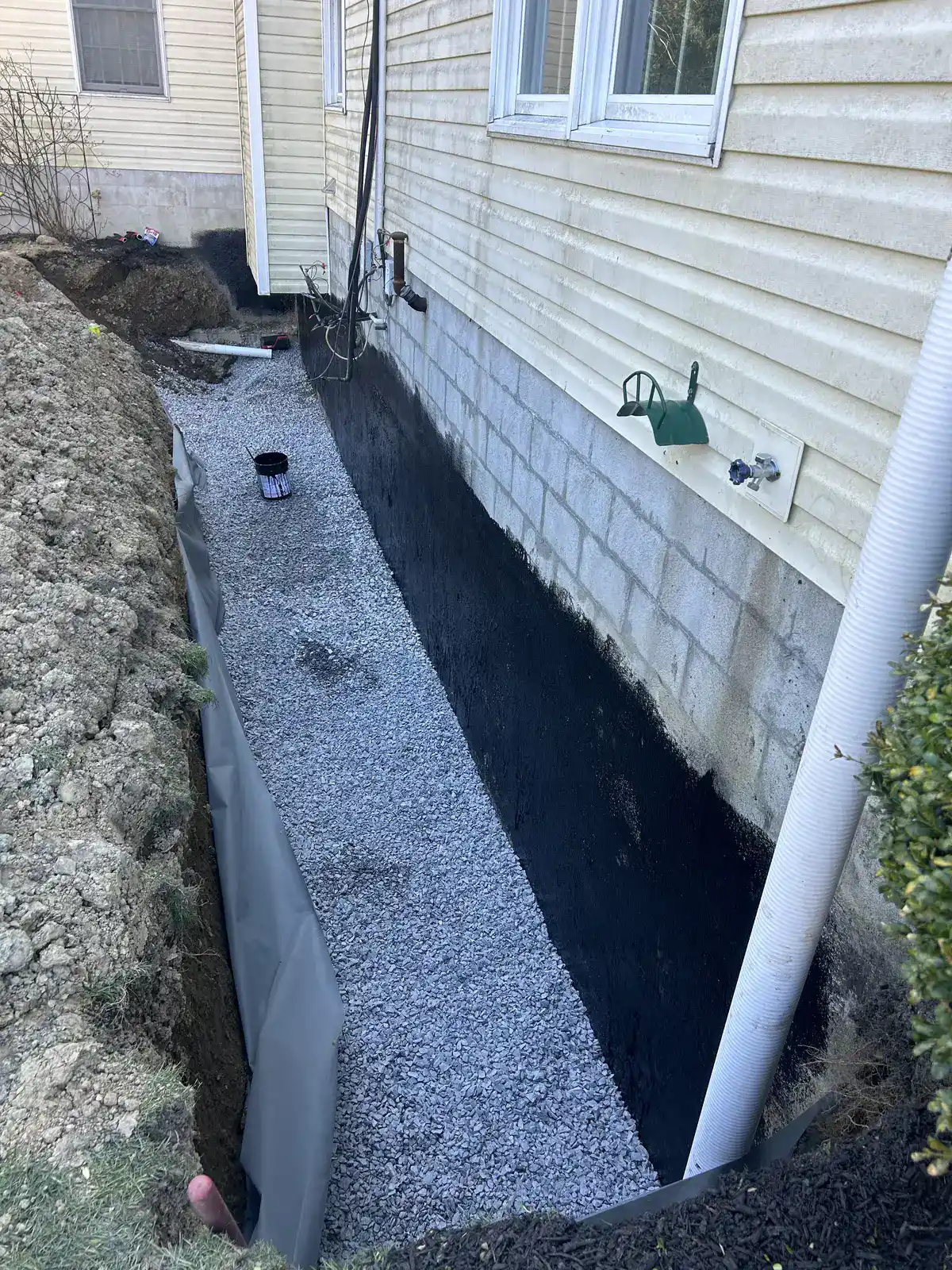 Footing drain installation at foundation wall