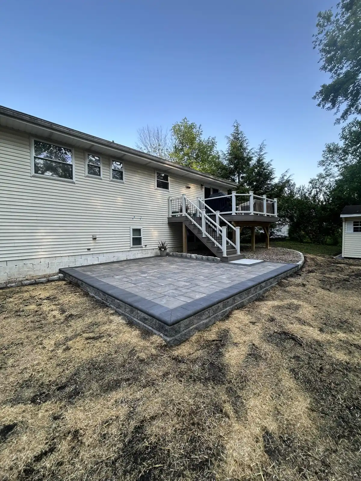Paver patio with retaining wall and deck stairs installed in Dutchess County NY