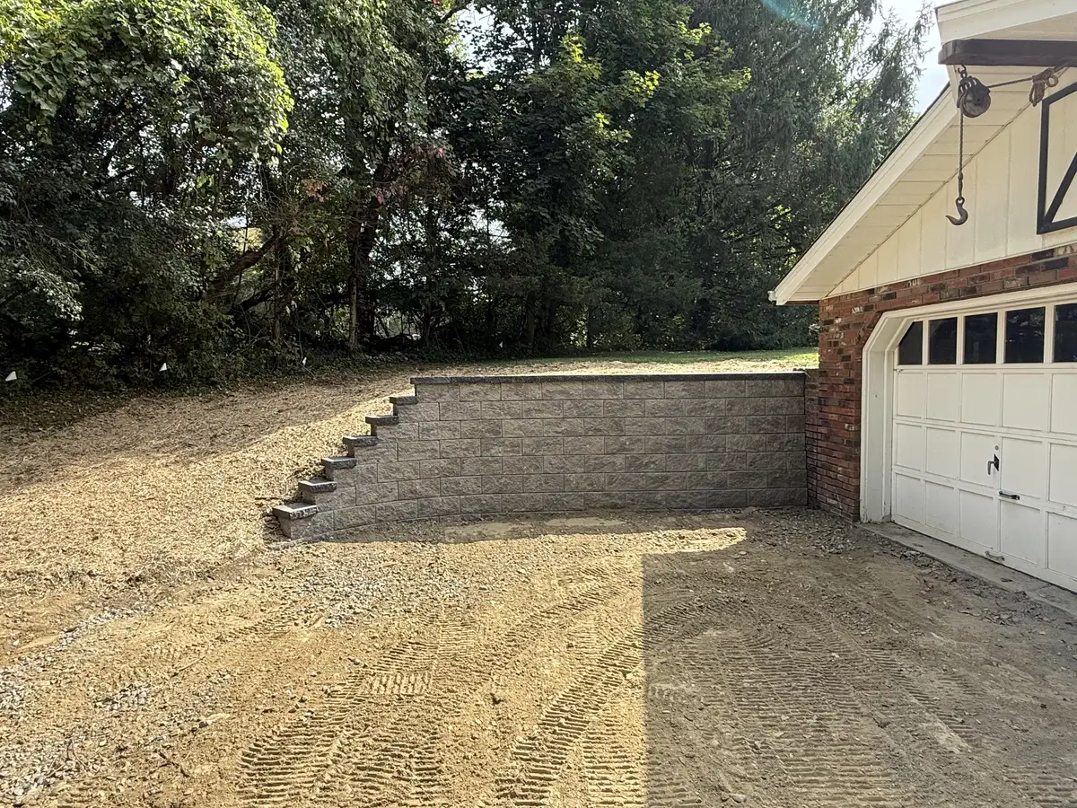 Retaining wall installation near garage with stone steps