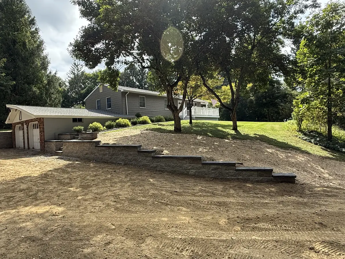 Hillside retaining wall with wide stone slab steps